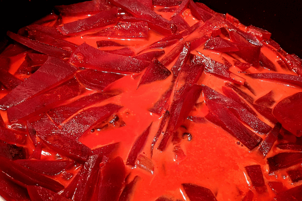 Chopped beets with seasonings and water cooking on a pan