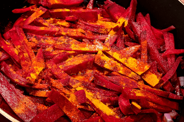 Chopped beets with seasonings cooking on a pan