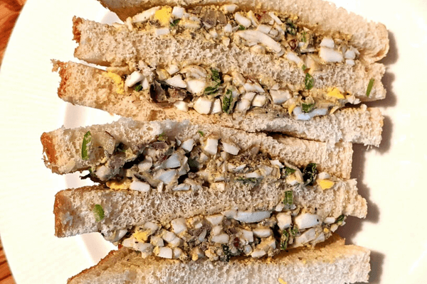 Egg salad sandwiches on a white plate