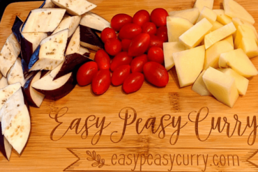 chopped aubergine, tomamtoes and potatoes on a cutting board