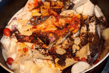 chopped aubergine, potatoes and tomatoes in a saucepan with spices