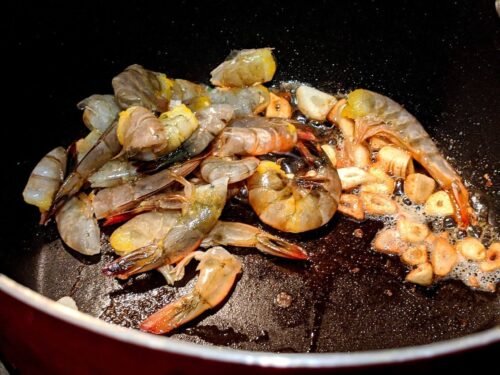 Chopped shrimp in a pan cooked in garlic and butter