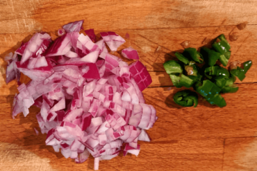 chopped onions and green chillies on a cutting board
