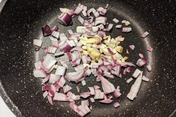 onion and garlic being fried in a pan