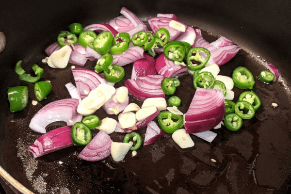 chopped onion, garlic and green chili on a pan