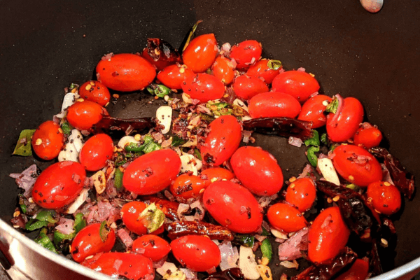 chopped vegetables and cherry tomatoes in a pan