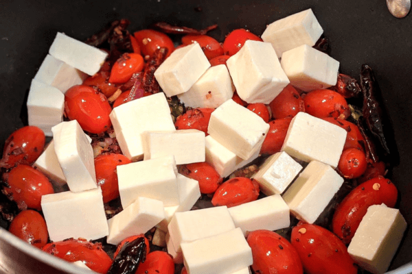tomatoes and paneer cubes in a pan