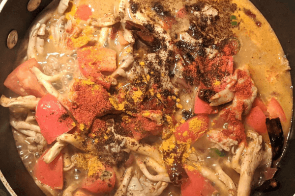 mushrooms cooked in a curry with spices added on top