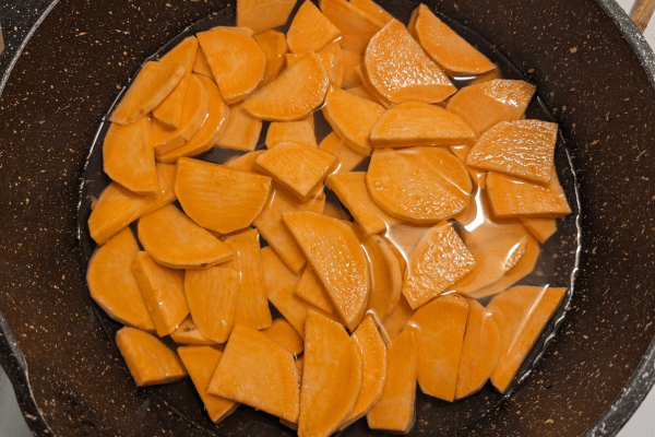 chopped sweet potatoes being boiled in a pot