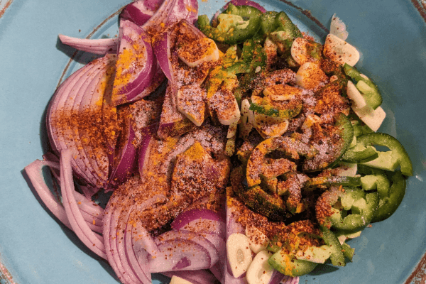 chopped onions, garlic, and jalapenos mixed with seasonings on a plate