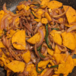 chopped onions, garlic and jalapenos and chopped sweet potatoes stir fried on a pan